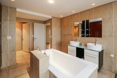 a bathroom with two sinks and a large tub at Ocean View 905 Self Catering Accommodation Strand Western Cape South Africa in Strand