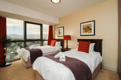 a hotel room with two beds and a large window at Ocean View 905 Self Catering Accommodation Strand Western Cape South Africa in Strand