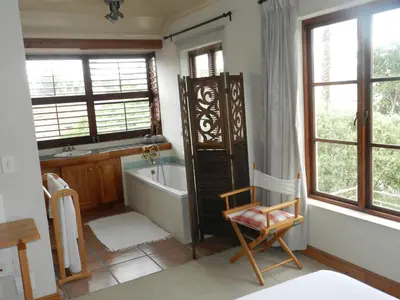 a bathroom with a bath tub and a sink at Sunset at Diluta in Cape Town