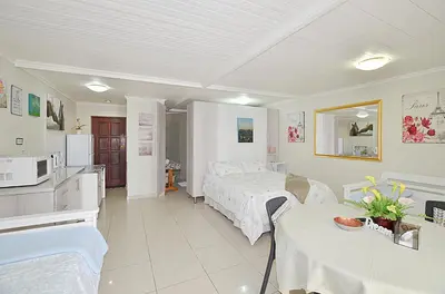 a hotel room with a bed and a kitchen and a room at Arum Field Accommodation in Table View