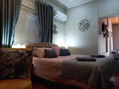 a bedroom with a bed and a clock on the wall at Mountainia Inn in Worcester