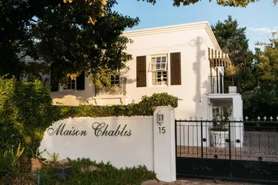 a white house with a white gate and a fence at Maison Chablis Guest House in Franschhoek