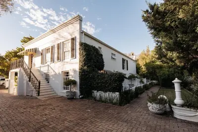 a white house with ivy growing on the side of it at Maison Chablis Guest House in Franschhoek
