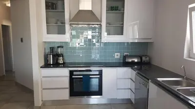 a kitchen with white cabinets and a sink at 109 da Gama on Beach in Strand