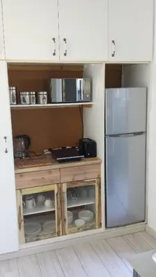a kitchen with white cabinets and a refrigerator at 29 Carissa Street in Somerset West