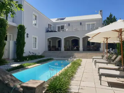 a house with a swimming pool and patio furniture at Maison d'Ail Guest House in Franschhoek