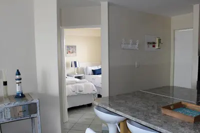 a bathroom with a toilet and a bedroom with a bed at 605 Nautica in Bloubergstrand