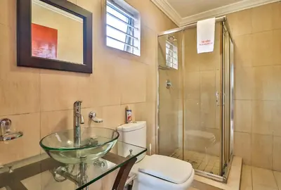 a bathroom with a glass sink and a toilet at Kwantu Guesthouse 2 in Cape Town