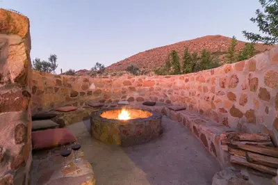 a stone fireplace in a stone wall with a fire pit at Olive Hill Guest House in Robertson