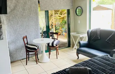 a living room with a couch and a table and chairs at Lemontree in Hermanus