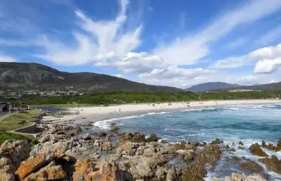 a group of people on a beach with rocks at Lemontree in Hermanus