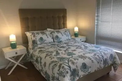 a bedroom with a bed with two lamps on tables at 325 Leisure Bay Cape Town in Cape Town