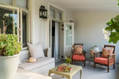 a porch with two chairs and a table at Cape Vue Country House in Franschhoek