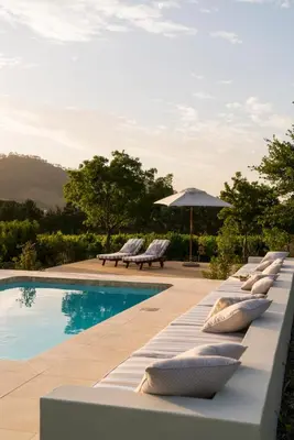 a row of lounge chairs next to a swimming pool at Cape Vue Country House in Franschhoek