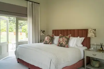 a bedroom with a large bed and a window at Cape Vue Country House in Franschhoek