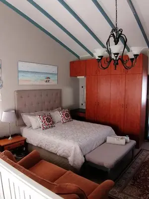 a bedroom with a bed and a chandelier at Siesta in Hermanus