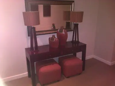 a table with two lamps and two stools under a mirror at Nautilus Guest House in Hermanus
