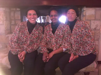 three women posing for a picture in front of a fireplace at Nautilus Guest House in Hermanus