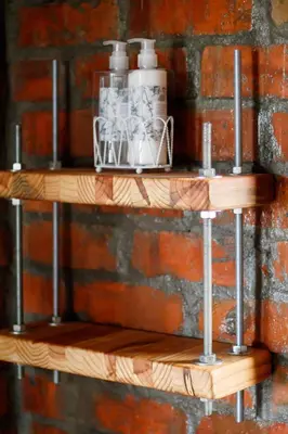 a wooden shelf on a brick wall with bottles andaments at Rustic Retreat Apartment in Durbanville in Durbanville