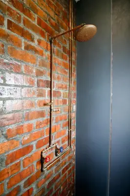 a bathroom with a brick wall with a light on it at Rustic Retreat Apartment in Durbanville in Durbanville