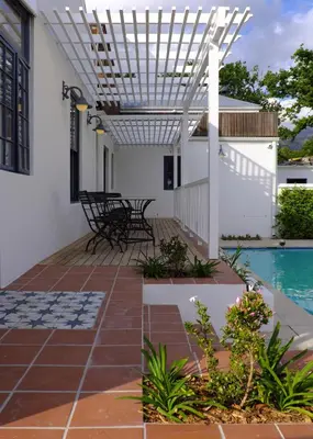 a patio with a pool and a pergola at Chapter House Boutique Hotel by The Living Journey Collection in Franschhoek