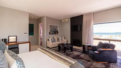 a hotel room with a bed and a view of the ocean at Atlantic Waves Guest House in Cape Town