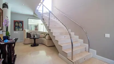a spiral staircase in a living room with a couch at Atlantic Waves Guest House in Cape Town