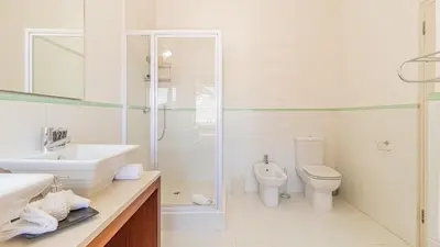 a bathroom with a toilet and a sink and a shower at Atlantic Waves Guest House in Cape Town
