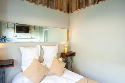 a bedroom with a bed with white sheets and pillows at Bedrock Guest Studios in Strand