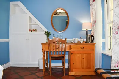 a bathroom with a wooden desk and a mirror at Knorhoek Country Guesthouse in Stellenbosch