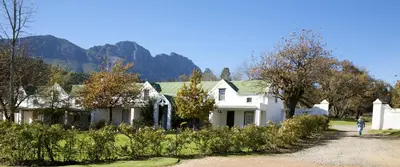 a white house with a mountain in the background at Knorhoek Country Guesthouse in Stellenbosch