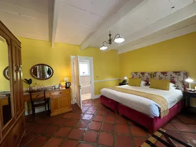 a bedroom with a large bed and a bathroom at Knorhoek Country Guesthouse in Stellenbosch