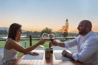 a man and a woman holding glasses of wine at Devonvale Golf & Wine Estate in Stellenbosch