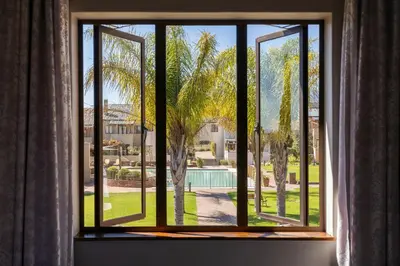 a window with a view of a palm tree at Devonvale Golf & Wine Estate in Stellenbosch