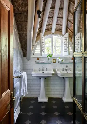 a bathroom with two sinks and a window at La Clé Lodge in Franschhoek