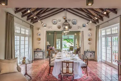 a dining room with a long table with white table cloth at La Clé Lodge in Franschhoek