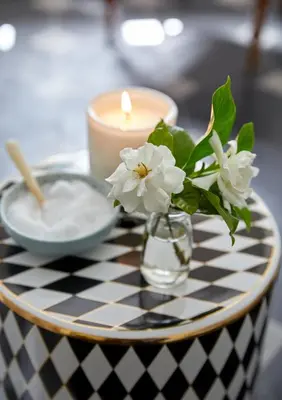 a candle and a vase with flowers on a table at La Clé Lodge in Franschhoek