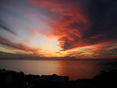 a sunset over a body of water at Studio with unforgettable View in Gordonʼs Bay