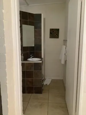 a bathroom with a sink and a mirror at Studio with unforgettable View in Gordonʼs Bay