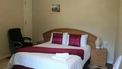 a bedroom with a large bed with purple and white pillows at Cape Town Milnerton Lagoon Villa in Cape Town