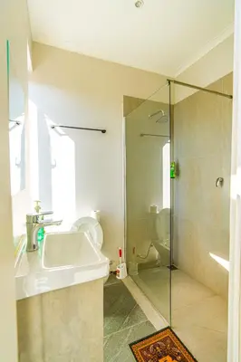 a bathroom with a sink and a glass shower at Cape Town Milnerton Lagoon Villa in Cape Town