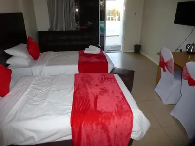 a hotel room with a bed with a red dress on it at Cape Town Milnerton Lagoon Villa in Cape Town