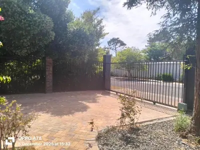 a wrought iron fence with a brick patio at Feet Up Cottage in Somerset West