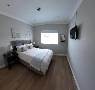 a bedroom with a large bed and a window at Heavenly Breeze in Hermanus