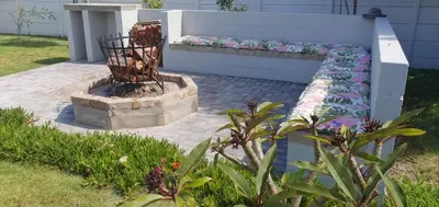 a bench with pillows on it in a garden at Heavenly Breeze in Hermanus