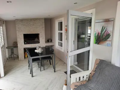 a living room with a table and a fireplace at Heavenly Breeze in Hermanus