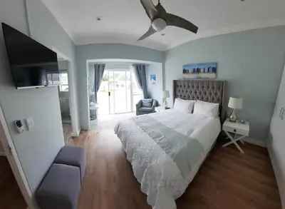 a bedroom with a large bed and a tv at Heavenly Breeze in Hermanus