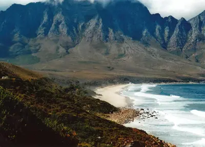 a view of a beach with mountains in the background at Nagua bay in Gordonʼs Bay