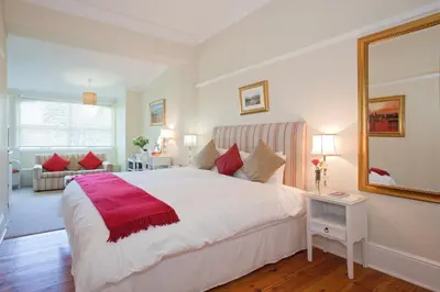 a bedroom with a large bed and a mirror at Brooklands House in Cape Town