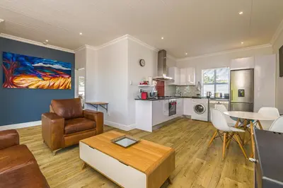 a living room with a couch and a table at Irene Avenue Apartment with sea views in Somerset West